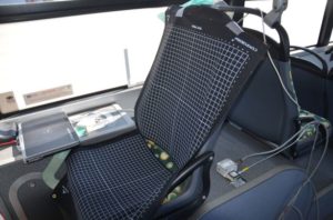 Siedzenie w pojeździe z nałożoną matrycą pomiarową i podłączonym sprzętem elektronicznym. Kontekst: testowanie lub kalibracja.
