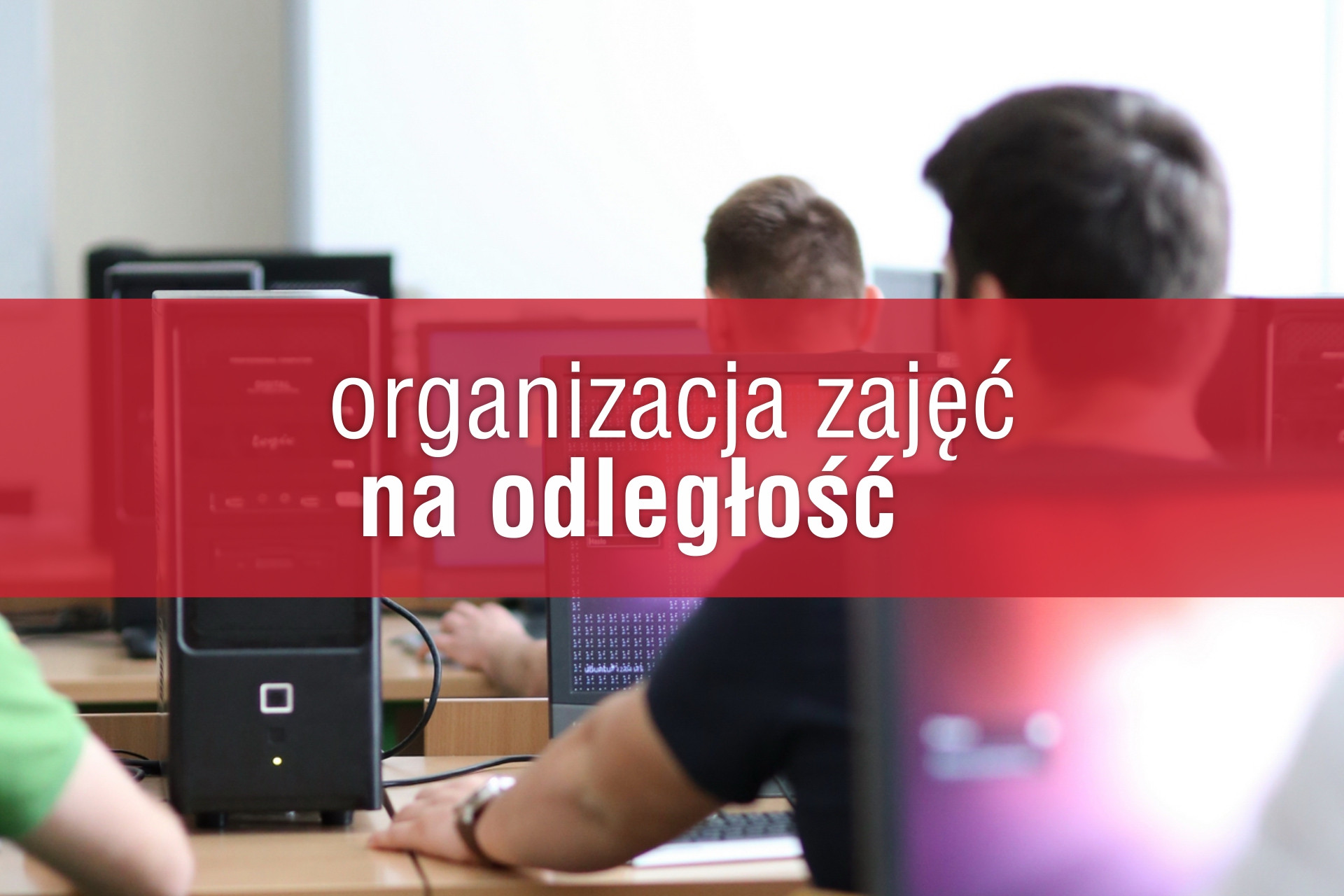 Komputery w sali lekcyjnej. Na ekranie napis "organizacja zajęć na odległość".